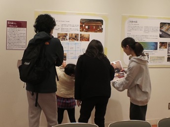 会場で長屋の拡大写真を見せながら説明をする学生